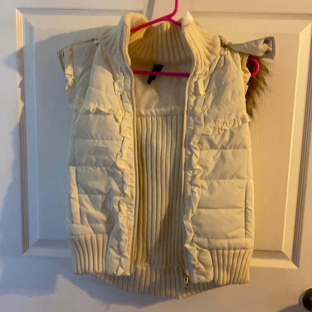 Take out light cream color sleeveless vest jacket with hood attached.